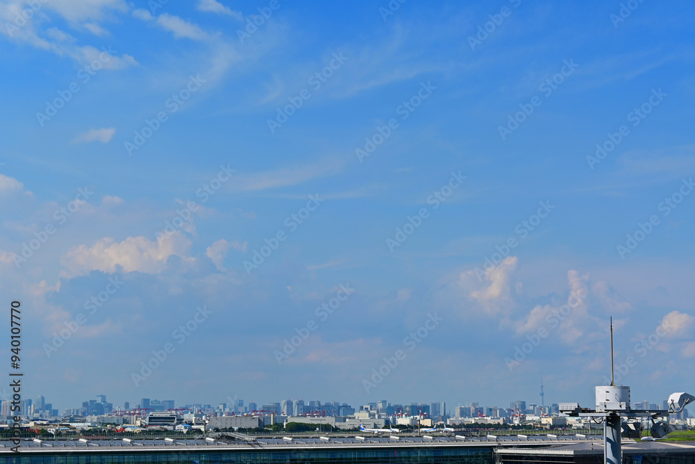 Obraz premium Summer sky in Tokyo, blue sky, banks of clouds, skyscrapers in the distance.