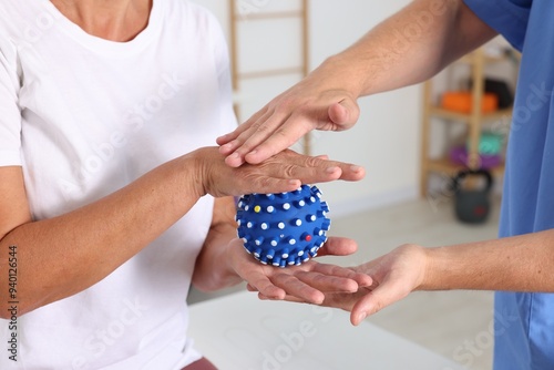 Physiotherapist working with senior patient in rehabilitation center, closeup photo