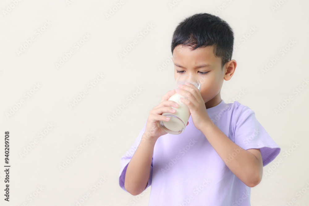 Asian child drinking milk on white background. Smiling of Asian boy with a glass of milk. Asian child drinking milk on white background. Smiling of Asian boy with a glass of milk.