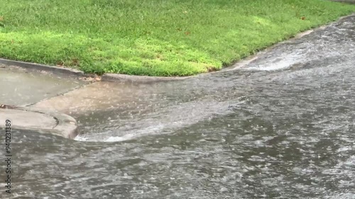 Flooding on a suburban street in the midwest - Heavy thunderstorms create flood conditions in a neighborhood area. Rainwater and runoff flowing in the suburbs