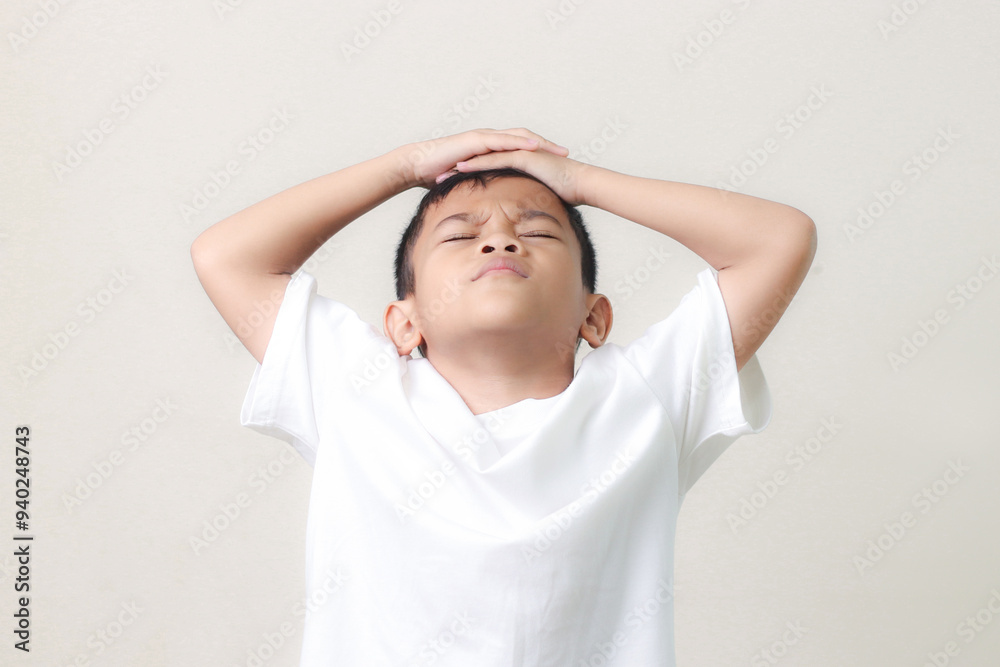 Frustrated little asian boy suffers from headache, keeps hands on temples, isolated on white background. Frustrated little asian boy suffers from headache, keeps hands on temples, isolated on white background.