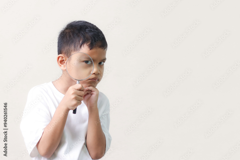 Portrait of surprised cute little asian boy looking through a magnifying glass. Education concept. Portrait of surprised cute little asian boy looking through a magnifying glass. Education concept.