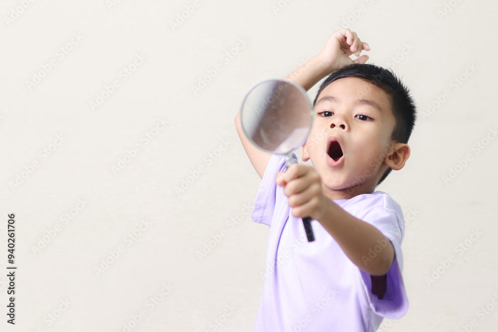 Portrait of surprised cute little asian boy looking through a magnifying glass. Education concept. Portrait of surprised cute little asian boy looking through a magnifying glass. Education concept.