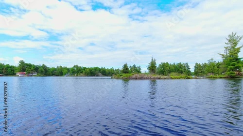 POV from the small boat boating through freshwater lake between spruce fir trees islands and vegetation. View for the boat front trolling moving during fishing. Beautiful North American dream view.