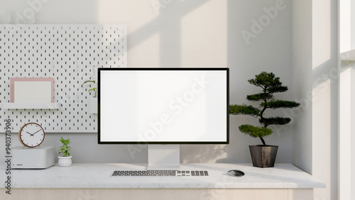 A modern white computer desk features a computer with a white-screen mockup and decor.