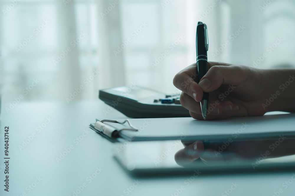 Obraz premium Working home concept .Person writing clipboard desk with tablet documents in bright office atmosphere, planning business tasks, taking financial notes planning taxes, calculating investment income.