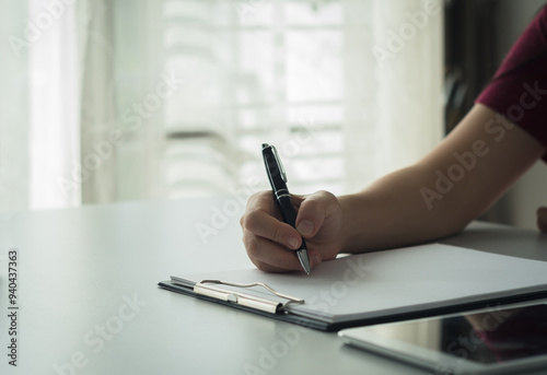 Person  working  writing in notebook with pen at table Business planning, work recording, financial recording, working with documents