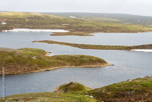 Beautiful lake Pettervannet with moraine ridges in the highlands of Varanger peninsula National Park on a partly cloudy June day photo