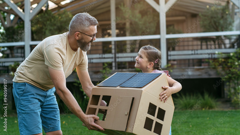 Dad and girl playing with house with solar panels on roof, learning about solar energy. Rooftop solar or photovoltaic system. Sustainable future for next generation. Dad and girl playing with house with solar panels on roof, learning about solar energy. Rooftop solar or photovoltaic system. Sustainable future for next generation.