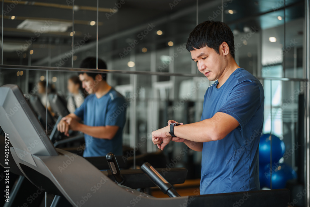 man running on treadmill and checking smart watch for performance at fitness gym exercise man running on treadmill and checking smart watch for performance at fitness gym exercise