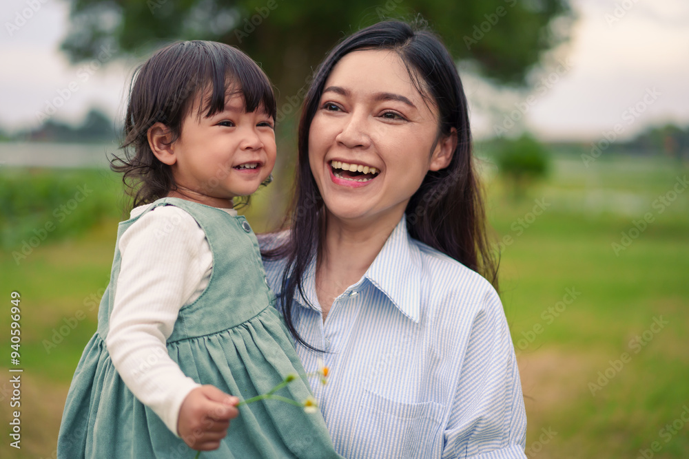 happy mother holding toddler baby girl on grass field in the park happy mother holding toddler baby girl on grass field in the park