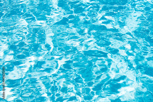 Blue pool water background. Blurred transparent clear calm water surface texture. Water waves in sunlight with copy space.