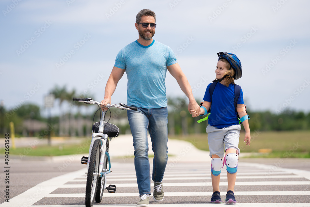 Safety on road. Pedestrian crossing for cyclists. Happy fathers day. Happy family, men generations. Concept of friendly family summer lifestyle. Father and son riding bike in american neighborhood. Safety on road. Pedestrian crossing for cyclists. Happy fathers day. Happy family, men generations. Concept of friendly family summer lifestyle. Father and son riding bike in american neighborhood.