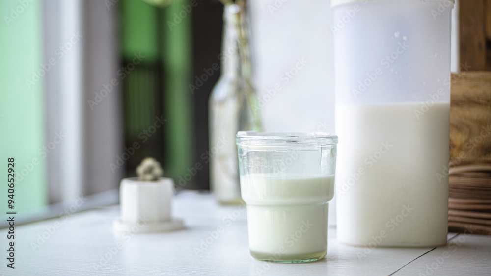 White milk in a glass with blurred background of ornamental plants White milk in a glass with blurred background of ornamental plants