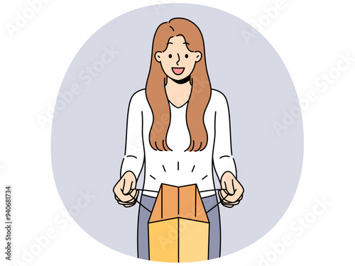 Woman holds paper bag and looks at screen showing off successful shopping and buying goods at big discount. Girl with paper bag made from recycled material is proud of concern for environment