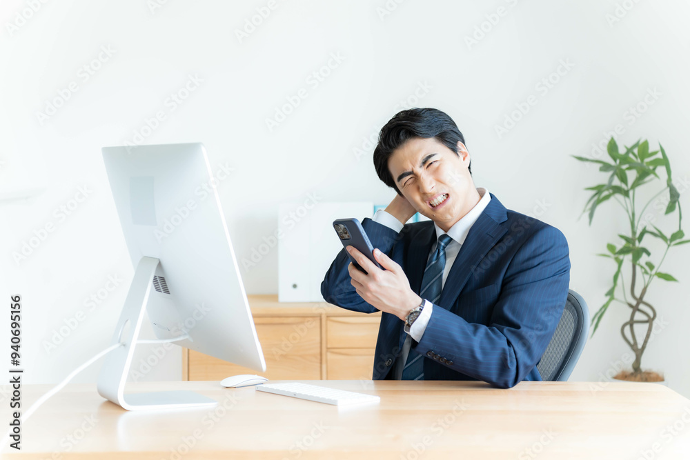 携帯を持ち落ち込むサラリーマン