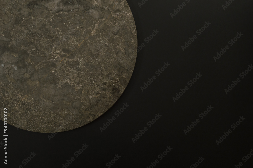 Top view of brown marble plate on black background. Food presentation, stone tray. Copy space, flat lay.