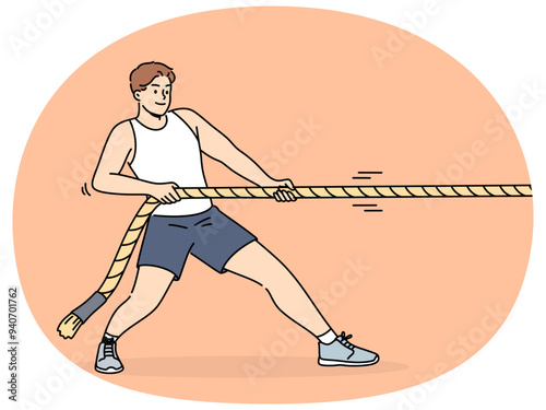 Strong man pulls rope while participating in sports competitions with rivals or training in fitness club. Strongman pulls rope alone, wanting to win tournament and get prize cup or medal.