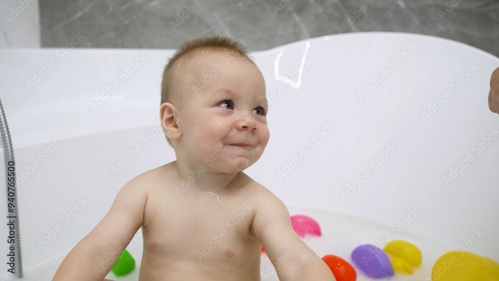 Baby boy playing with toys while taking bath. Baby boy playing with toys while taking bath.