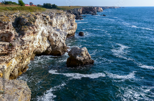 Seascape on the Black Sea, high steep stone coast with inaccessible rocks photo