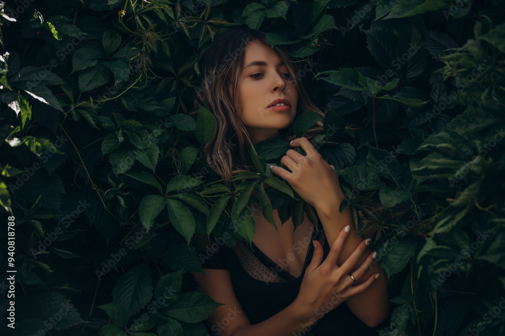 Young adult woman in a summer green garden on a background of leaves Young adult woman in a summer green garden on a background of leaves