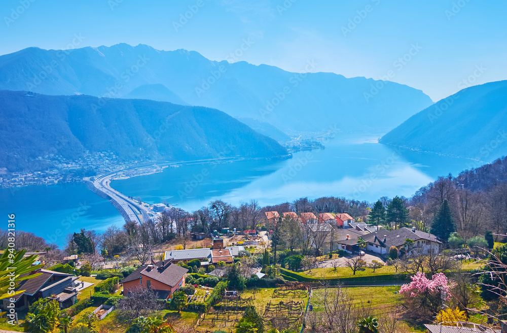 Carona gardens behind Melide Causeway and hazy Alps, Ticino, Switzerland