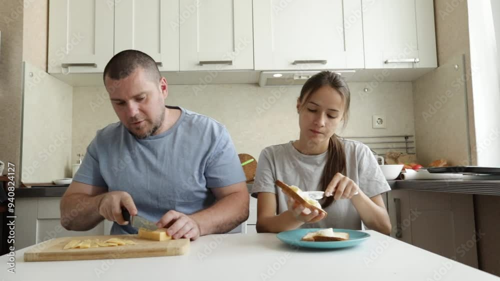 Teenage girl and father cooking breakfast at the kitchen, preparing food together, enjoying family time. Teenage girl and father cooking breakfast at the kitchen, preparing food together, enjoying family time.