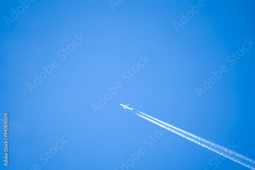 high altitude twin engine contrails (jet airplane vapour trails) across a deep blue clear sky