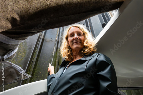 Photography Stockholm, Sweden A woman in a raincoat holds a rope inisde a boating lock onthe