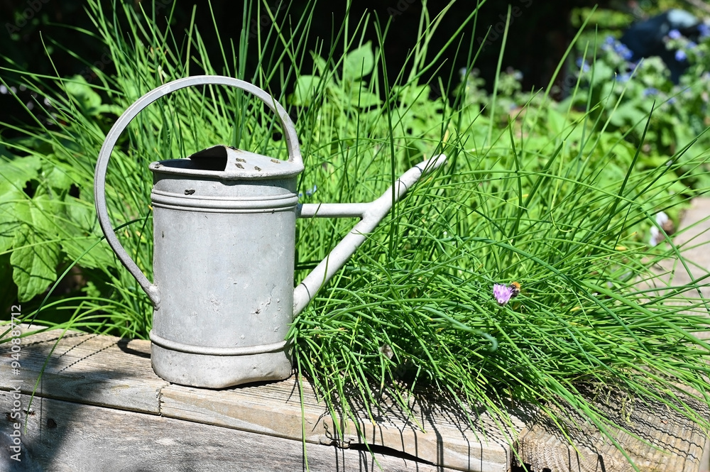 Gießkanne aus Blech im Garten mit Hochbeet Gießkanne aus Blech im Garten mit Hochbeet