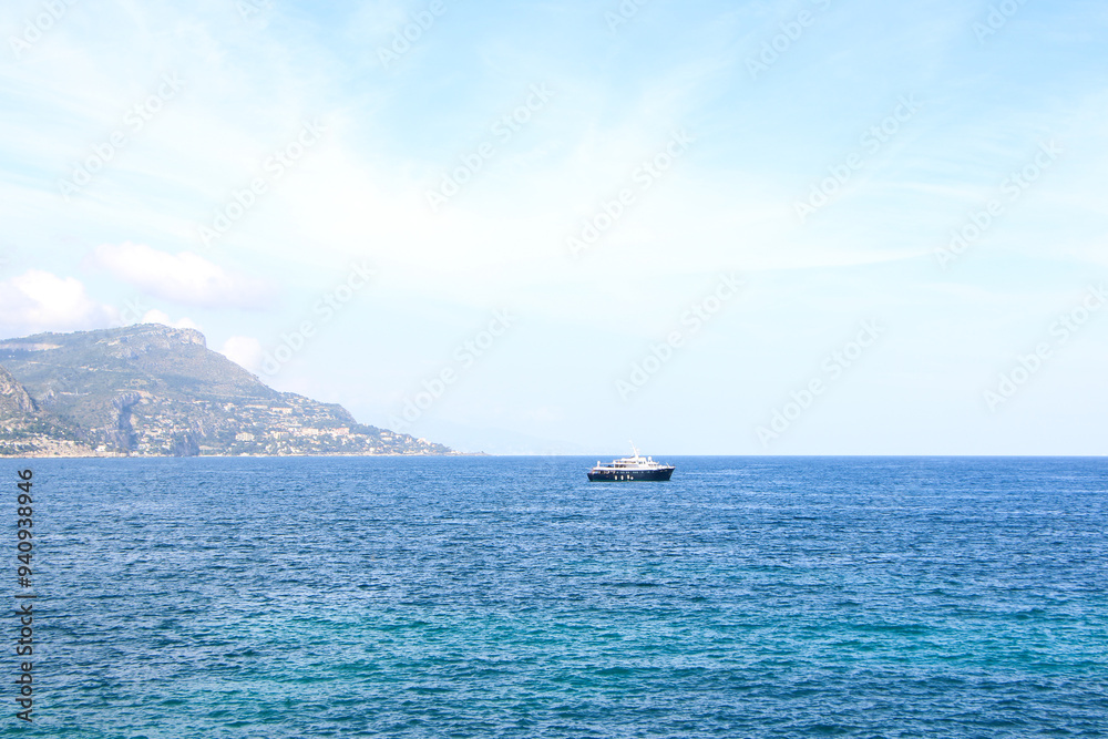 French Riviera coastline with lush green vegetation in the foreground, framed by rugged mountains and the blue Mediterranean Sea, dotted with yachts. Ideal for travel and nature-related content. French Riviera coastline with lush green vegetation in the foreground, framed by rugged mountains and the blue Mediterranean Sea, dotted with yachts. Ideal for travel and nature-related content.
