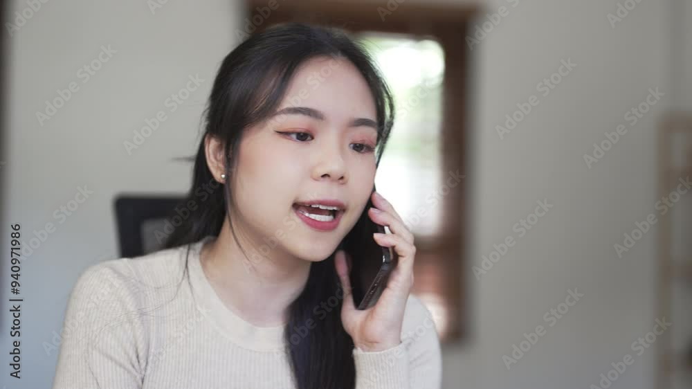 Asian female using smartphone for call at her home Asian female using smartphone for call at her home