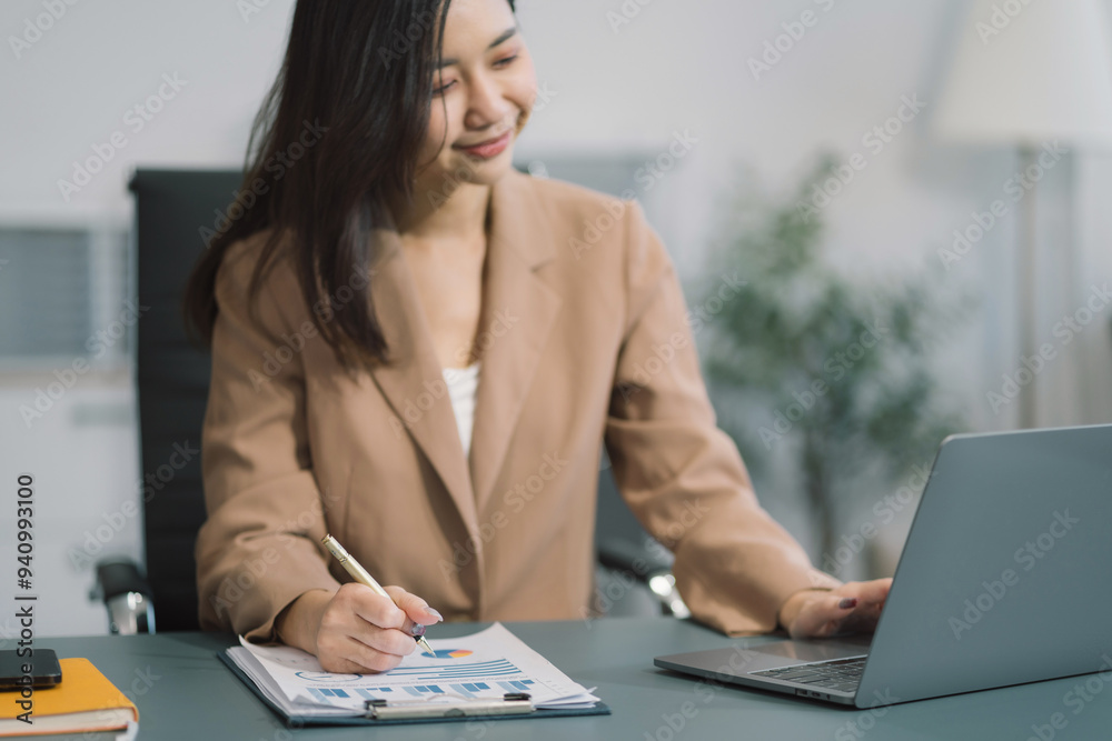 Fototapeta premium Business documents on the desk with a laptop and a Tablet with graphs, business diagrams and women working in the office.