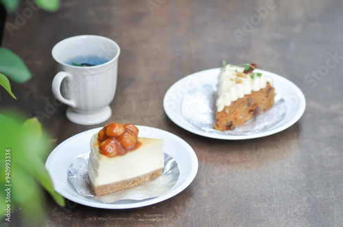 carrot cake with cream and walnut topping ,caramel macadamia cheesecake and butterfly pea tea photo