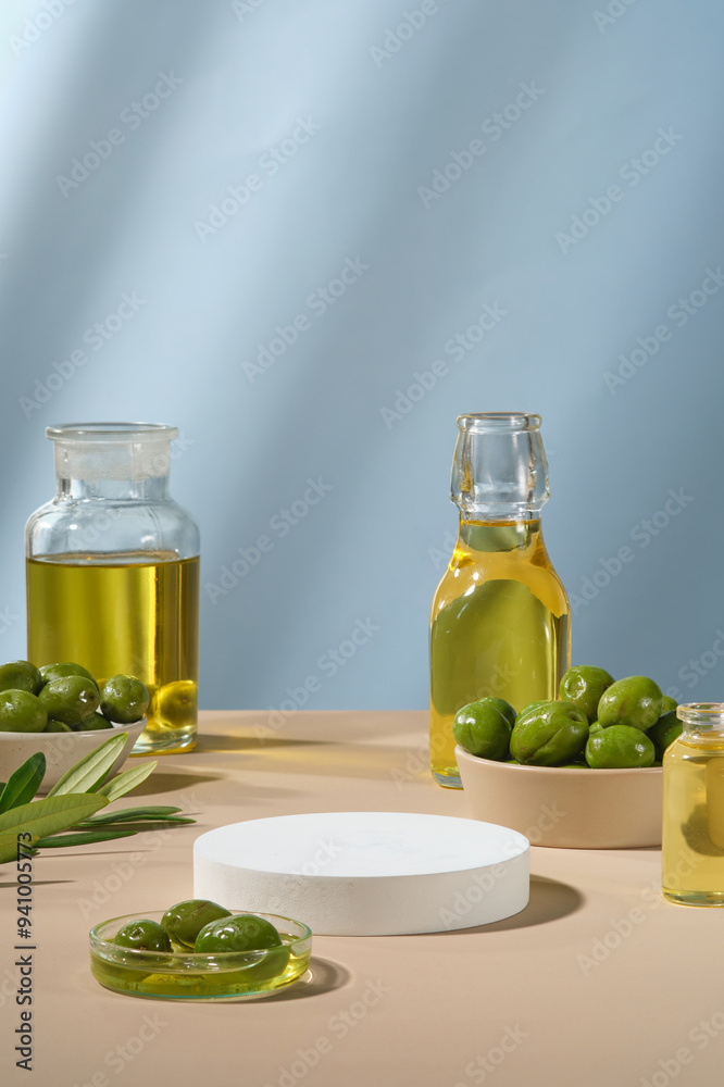 Pedestal for display cosmetic product of olive extract with white empty podium, fresh olives and olive oil on blue background. Olives contain many healthy nutrients Pedestal for display cosmetic product of olive extract with white empty podium, fresh olives and olive oil on blue background. Olives contain many healthy nutrients