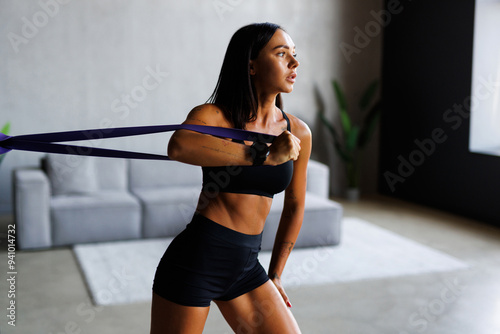 Woman during home workout with a rubber resistance bands at home