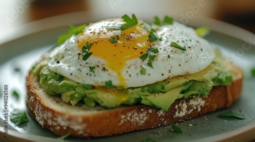 Delicious Avocado Toast with Sunny Side Up Egg and Fresh Herbs on Rustic Bread