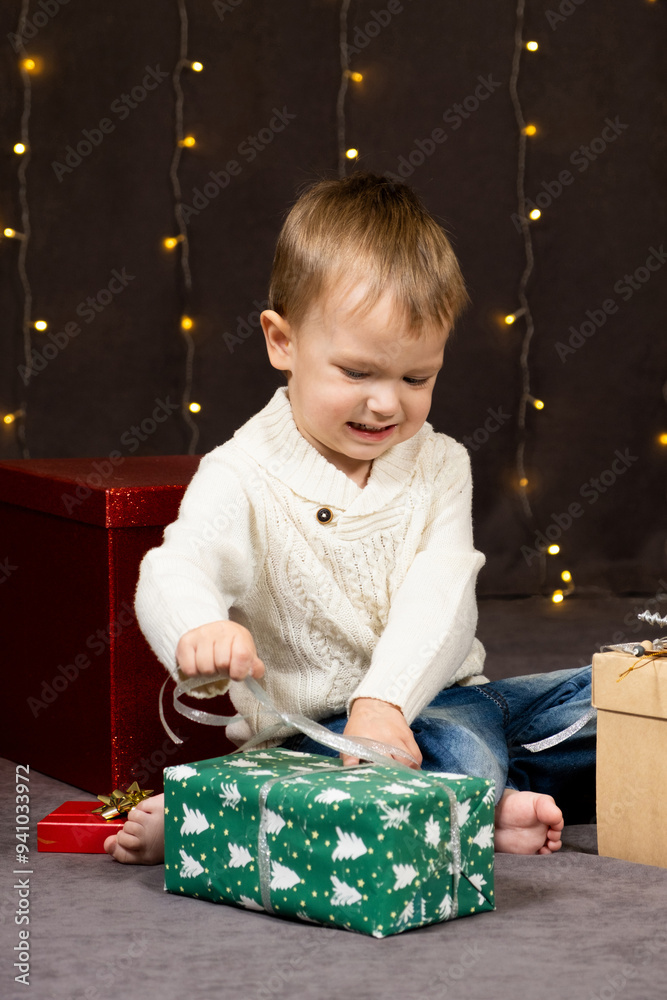 Little two-year-old boy opens Christmas gifts at home Little two-year-old boy opens Christmas gifts at home