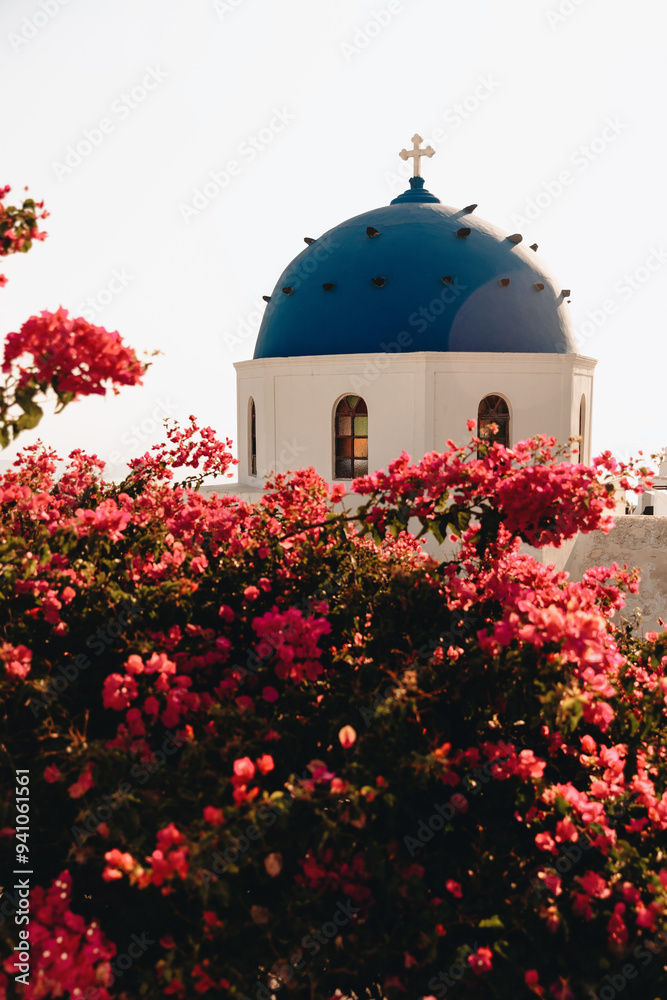 Obraz premium Blue-Domed Church in Imerovigli Framed by Blooming Bougainvillea, Santorini, Greece