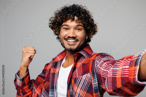 Sticker Close up young happy cool Indian man he wearing red shirt casual clothes doing selfie shot pov on mobile cell phone do winner gesture isolated on plain grey color background studio