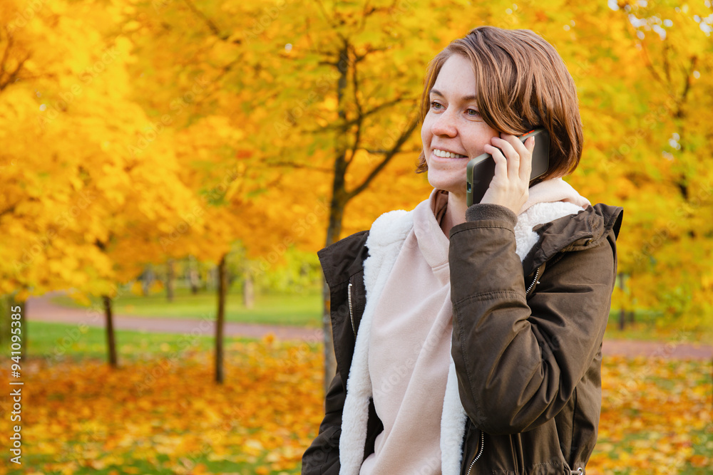 Smiling Woman Talking on Phone in Autumn Park Smiling Woman Talking on Phone in Autumn Park
