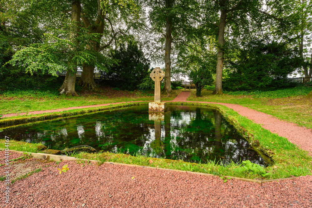 Fototapeta premium The Cross at Lady's Well in Holystone, a small Village at Upper Coquetdale in Northumberland National Park, England, where the Holy Well supplies the village with water