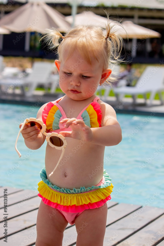 little girl on the background of the pool in a beautiful swimsuit and sunglasses. rest. little girl on the background of the pool in a beautiful swimsuit and sunglasses. rest.