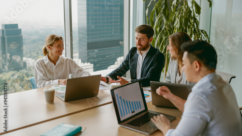 A highly productive team meeting is actively taking place in a modern office, concentrating on detailed data analysis