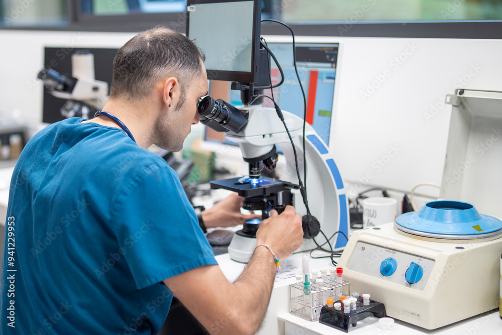 Veterinarian analyzing samples under a microscope in a laboratory Veterinarian analyzing samples under a microscope in a laboratory