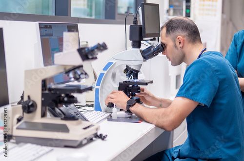 Veterinarian examining samples under a microscope in a lab
