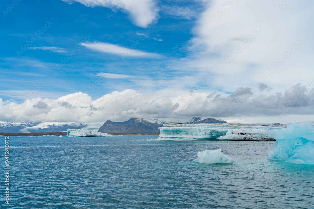 Joekulsarlon Glacier Lagoon Landscape with blue ice at south Iceland, background a mountain range with snow Joekulsarlon Glacier Lagoon Landscape with blue ice at south Iceland, background a mountain range with snow