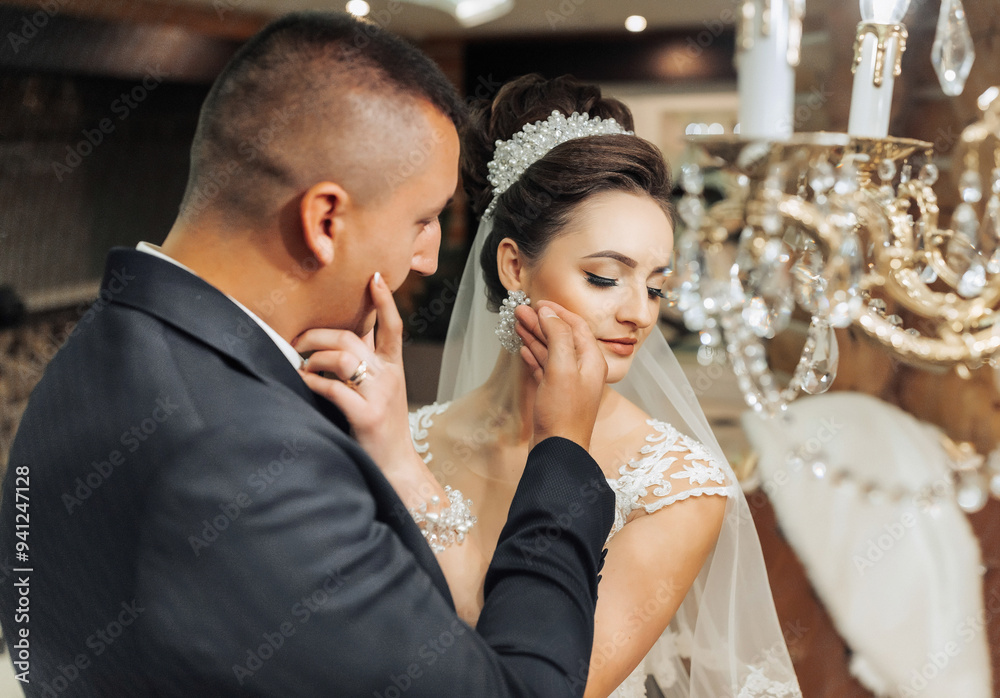 A man and a woman are standing in front of a chandelier A man and a woman are standing in front of a chandelier