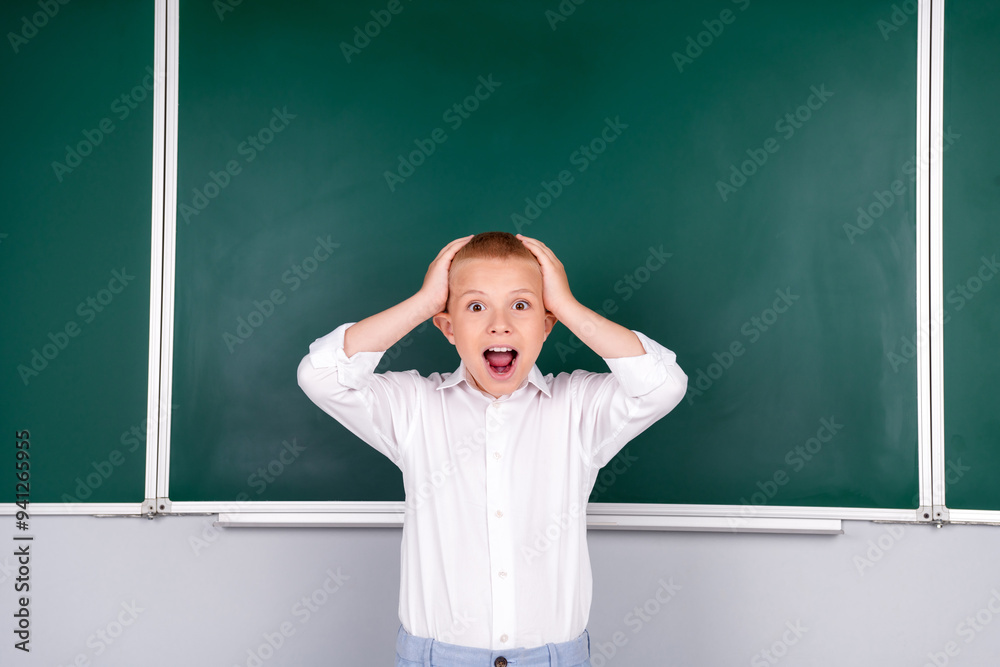 Photo of funny crazy glad boy schoolkid hand head standing green board in class room Photo of funny crazy glad boy schoolkid hand head standing green board in class room