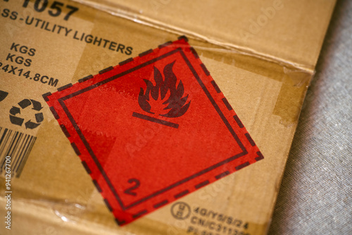 Safety label with flammable icon on cardboard packaging